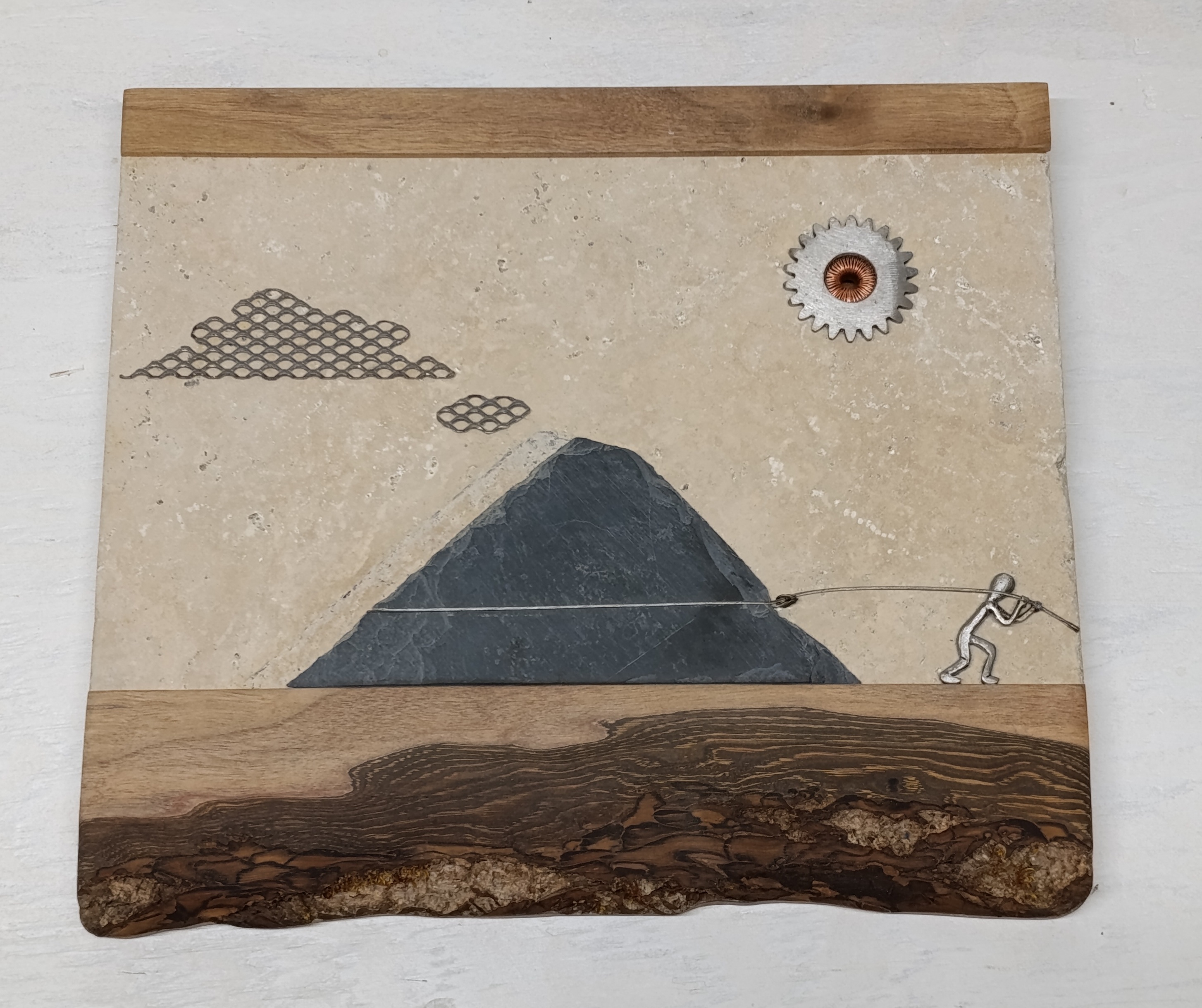 Tableau relief métal pierre sur l'effort humain face à la montagne.